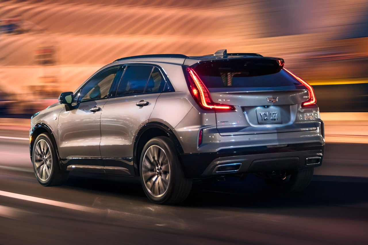 Rear View of the 2025 Cadillac XT4 Driving Fast Through the City at Night