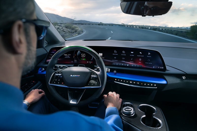 Front View of the 2026 OPTIQ-V Driving Through the Dusk Utilizing its Headlights | All American Cadillac in MUNCIE IN